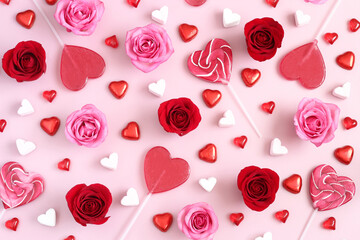 Valentines Day background with red and pink roses and heart shaped candies