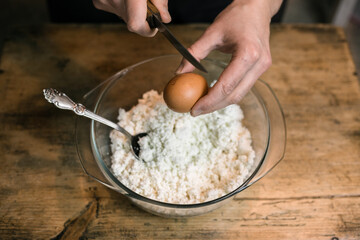 Fototapeta premium Breaks a chicken egg and adds to the curd