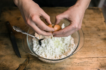 Breaks a chicken egg and adds to the curd