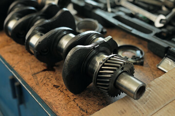 Part of the car's engine is lying on a table in the workshop. Auto disassembly and sale of spare...