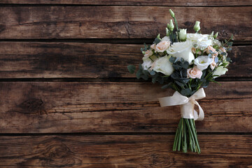 Beautiful wedding bouquet on wooden table, top view. Space for text