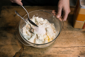 Adding sugar to curd with a spoon