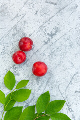 Fresh plums with leaves on the table close-up. Copy space. High quality photo