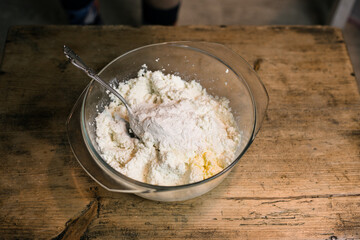 Stirring curd with chicken eggs. Cooking casseroles.