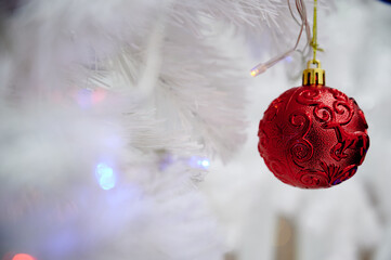 Red Christmas ball toy on a white Christmas tree