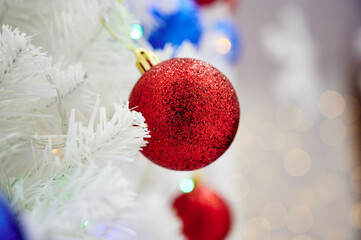 Red Christmas ball toy on a white Christmas tree