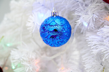 Blue Christmas ball toy on a white Christmas tree