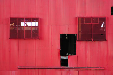 A low, wide-angle view of the red storage structure of an old, abandoned mill in Mesa, Arizona © Eduardo Barraza