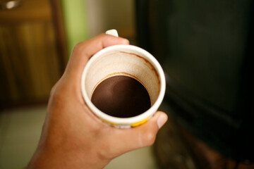 hand holding empty cup of coffee. Dregs in the bottom of the cup