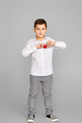 valentine's day. cute little child boy holding red heart isolated on gray background