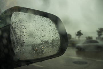 Rain drops on car side mirror.