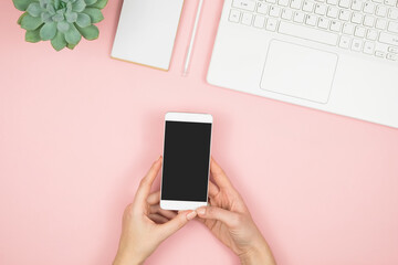 Mobile phone in hand screen on pink background. Love in social media. Women workspace. Happy Valentine's day