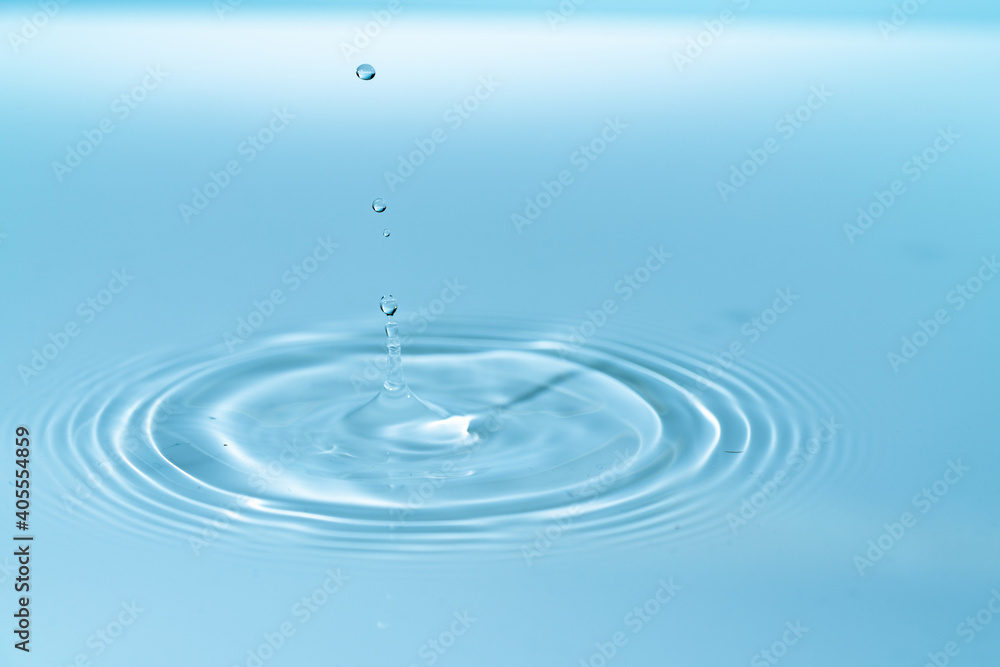Wall mural drop of water drop to the surface. waves on the surface of the water from a collision