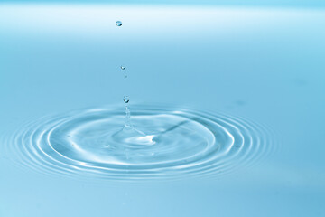 Fototapeta na wymiar Drop of water drop to the surface. Waves on the surface of the water from a collision