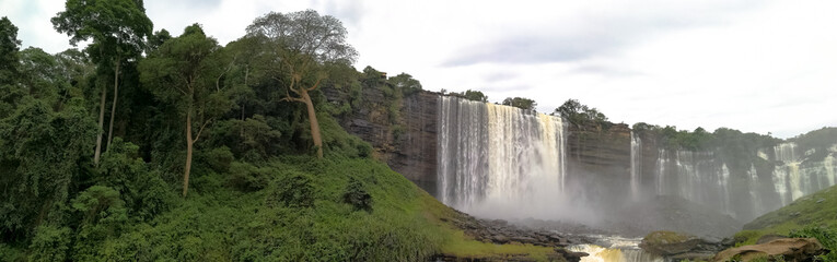 Calandula waterfall, river and green grass, jungle, water rushing, a big cascading waterfall, with green grass and jungle. in Angola