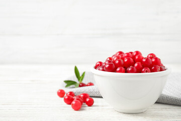 Tasty ripe cranberries on white wooden table. Space for text