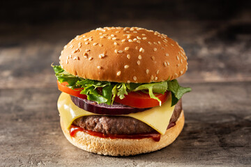 Cheeseburger with beef,tomato, lettuce and onion on wooden table