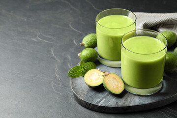 Fresh feijoa smoothie and fresh fruits on grey table, space for text