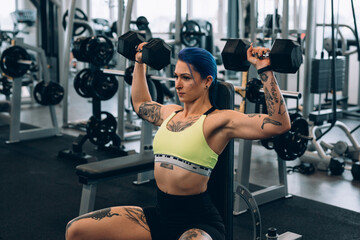 Fototapeta na wymiar tattooed woman training in gym