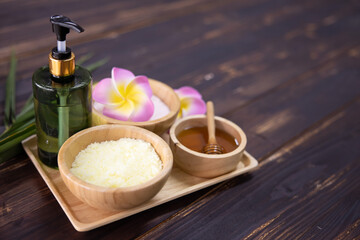 Fototapeta na wymiar View of Spa Treatment Set with Massage Oil Sea Salt and Honey on the Wooden Table