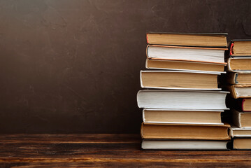 a stack of hardcover books on a dark background copy space