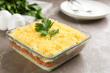 Traditional russian salad Mimosa served on marble table