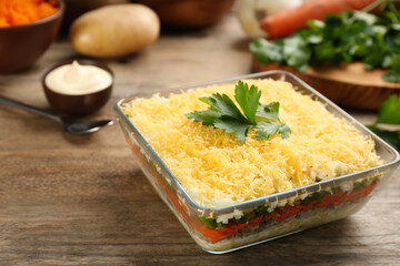 Traditional russian salad Mimosa served on wooden table