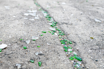 a lot of broken glass of different colors on the asphalt