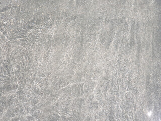 The texture of clear water glistening in the sun. Clear sea water for background and texture. Beautiful patterns of nature