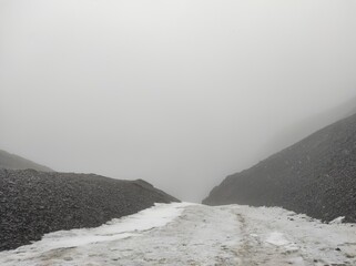 Snow, mist and stoned ground,hills on the pick of the mountain