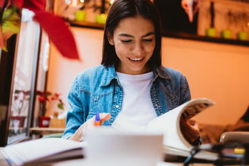 Portrait of cheerful young woman making notes