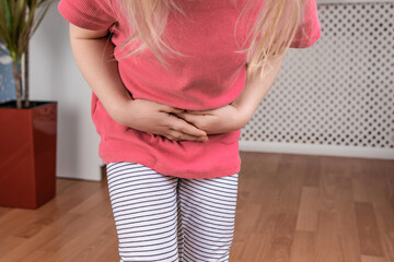 child keeps hands on belly at home. abdominal pain in a child. poisoning in children