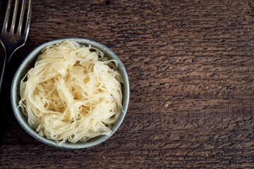 Fermented cabbage in a small bowl, top view with copy space