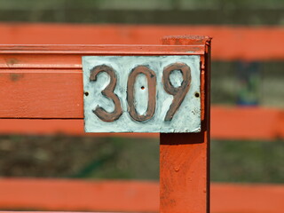 Tabliczka z numerem na drewnianym ogrodzeniu © Jacek