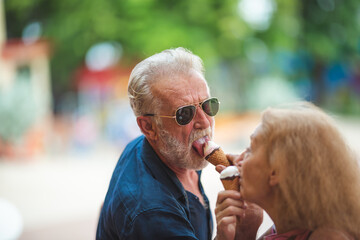 senior old couple celebration for Valentine's Day at Amusement theme park enjoying freedom relaxing, grandmother and grandfather smiling and fun, time to date and married