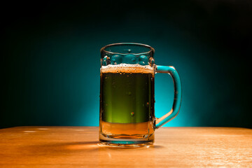 A mug of  beer stands on the table on a blue background