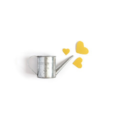 Yellow hearts made of cardboard and a gray tin watering can are on a white background. Minimalistic concept for valentine's day. Flat lay. Top view. Copy space.