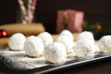 Fototapeta na wymiar Christmas snowball cookies on baking tray, closeup