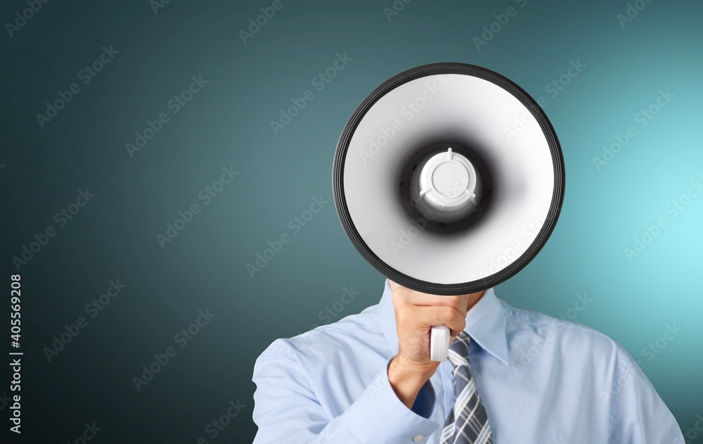 Wall mural young businessman talking on the megaphone on background