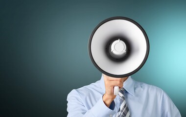 Young businessman talking on the megaphone on background