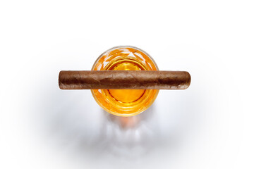 Closed up view of glass of whiskey with cigar on top on white back