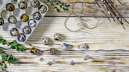 Quail eggs Easter background. Quail eggs, willow twigs, sprigs of herbs, twine on a wooden background, top view, frame, flat lay, copy space. Easter composition in th