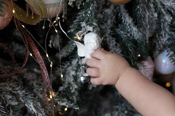 children's feet on a new year's background with tangerines and Christmas balls. a toy snowflake in a child's hand