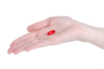 Red pill capsule in hand on white background isolation