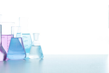 Chemical glassware with colored reagents on a white background. Selective focus. Medical, science and health care concept. Place for your text.