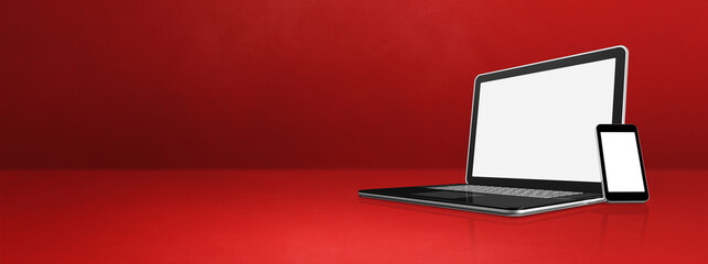 Laptop and mobile phone on red office desk banner