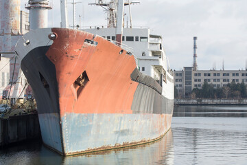 Old ship near the pier in the port.