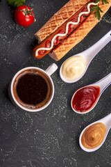 Hot dogs, fried potatoes and sauces on wooden background. Fast food, american tradditional meal. top view, copy space