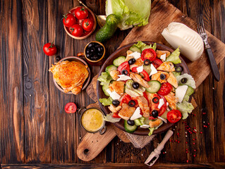 Fototapeta na wymiar Vegetable and meat salad of mozzarella, cheese, olives, chicken, cucumber, tomatoes. Low carb dietary food.