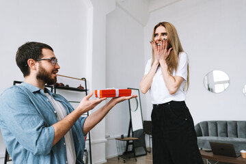 Man surprised his girlfriend with gift, happy couple celebrating valentines day or anniversary